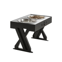 Indlæs billede til gallerivisning Stylish black pet feeding station with two stainless steel bowls, featuring paw print design and a sturdy X-shaped support that can be adjusted according to the pet's growth
